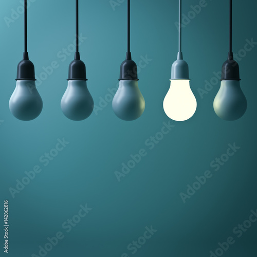 One hanging light bulb glowing different standing out from unlit incandescent bulbs with reflection on dark green background , leadership and different business creative idea concept. 3D rendering.
