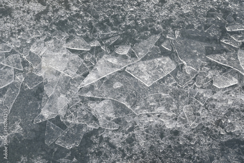 Abstract background of shards of broken ice glittering in the sun on the ice on a frozen lake photo