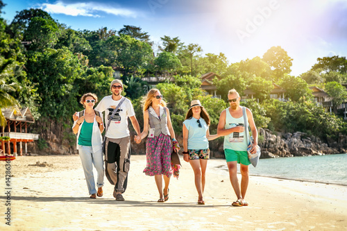 A group of young people friends 30 years walk on the beach, happy, real emotions, a vacation on the tropical shore