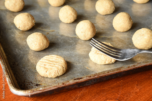 Φωτογραφία Rolled balls of oatmeal cookie dough on a seasoned cookie sheet  in window light