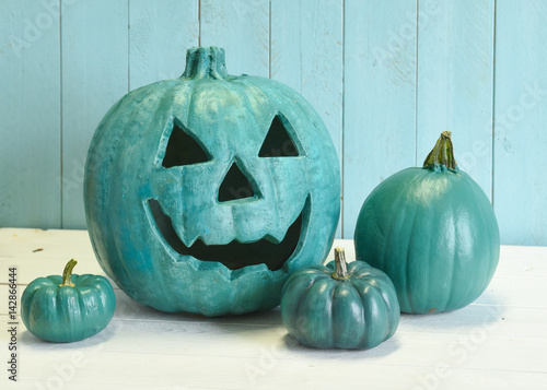 Teal pumpkins in a Halloween still life indicating that both allergy safe non food treats as well as candies are available to trick and treaters.