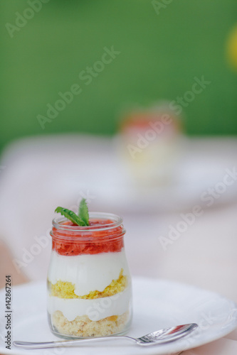 Erdbeer Creme Dessert im Glas geschichtet auf Picknicktisch photo