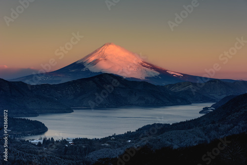 夜明けに紅に染まる冬の富士山と芦ノ湖
