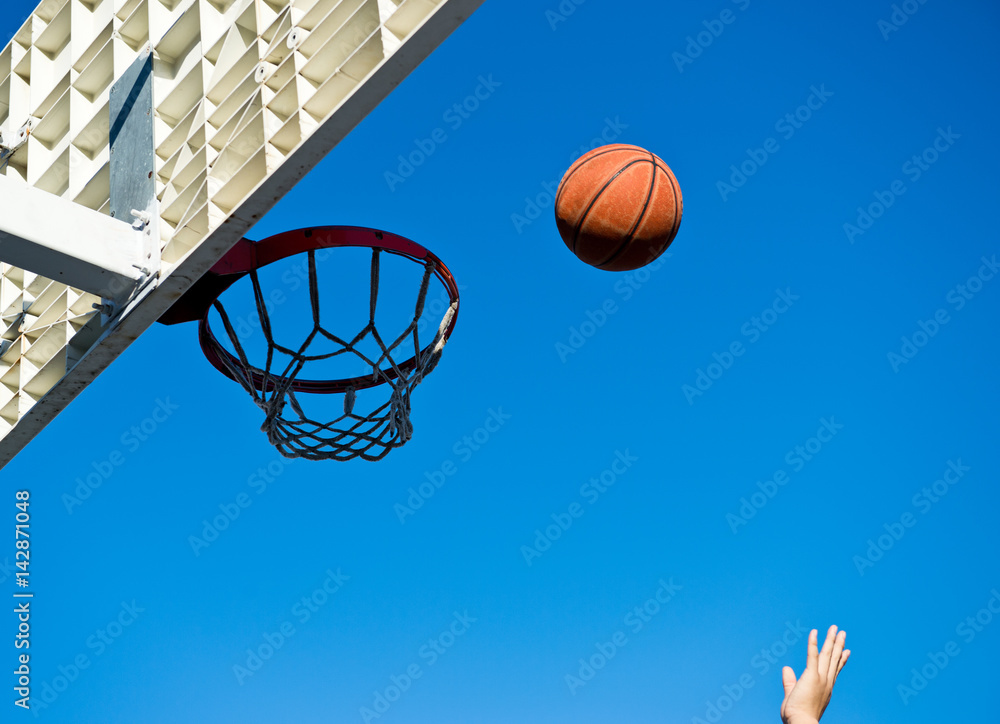 A basketball field goal with the sky in background.