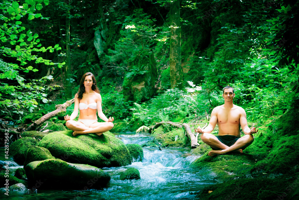 Fototapeta premium Couple Doing Yoga By The River