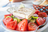 Greek feta salad with tzatziki and bread in the background