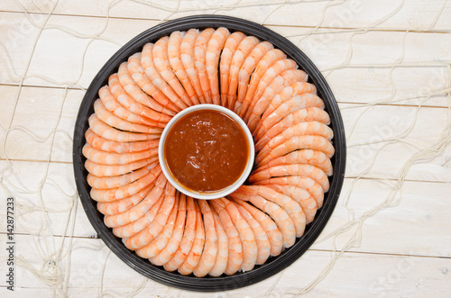 A Shrimp ring with seafood sauce on a rustic wood background