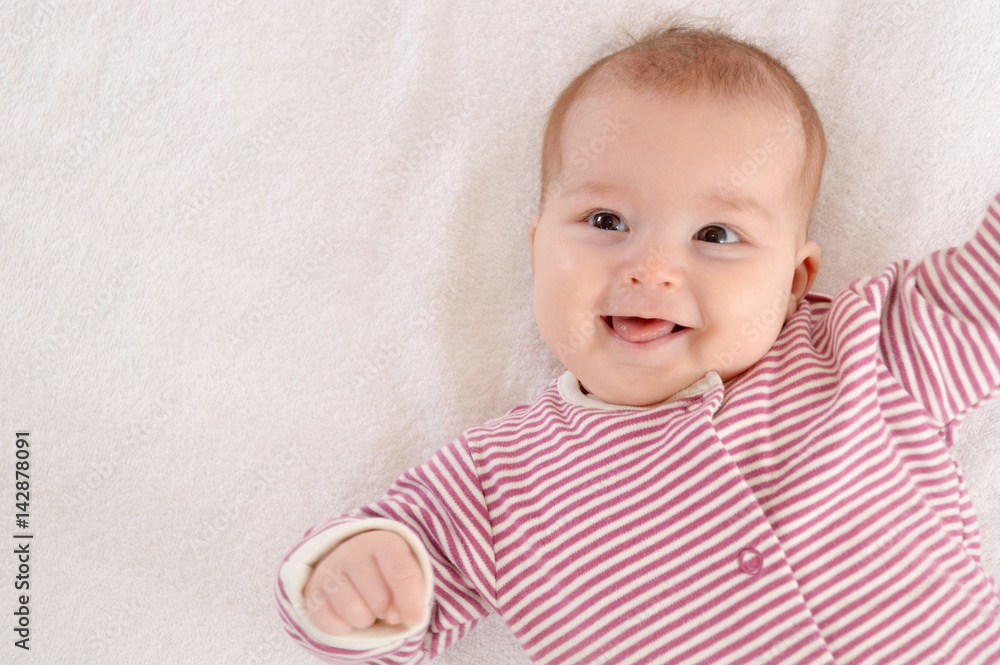 Happy newborn girl lying on her back and laugh Happy newborn girl lying on her back and laugh