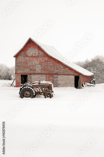 Vintage tractors in front of an old red barn at Christmas