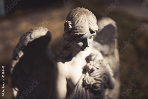 Statue of a winged angel in the dark.