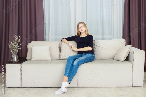 cute young girl relaxing on couch at home
