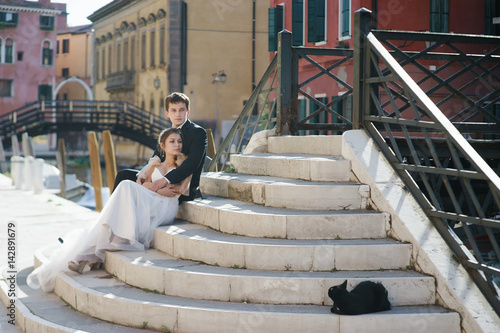 Young couple bride and groom and black cat in Venice