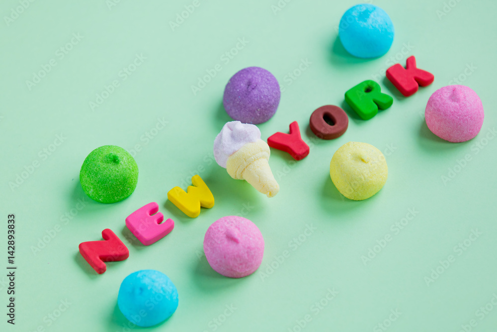 photo of colorful and ice cream marshmallows and colorful letters on the wonderful green background