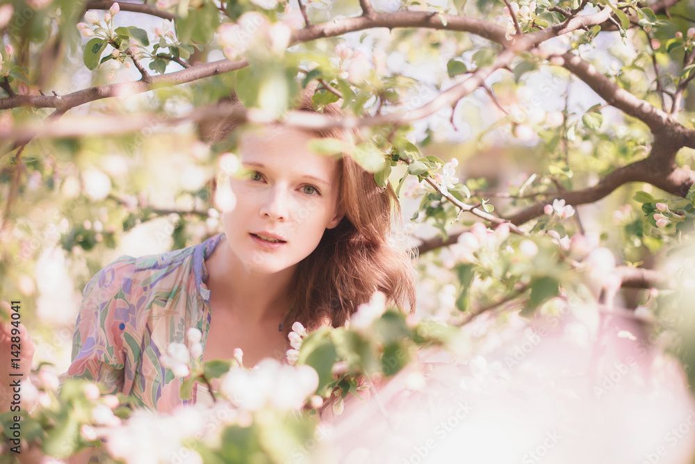 Beautiful lady on a background a blossom tree
