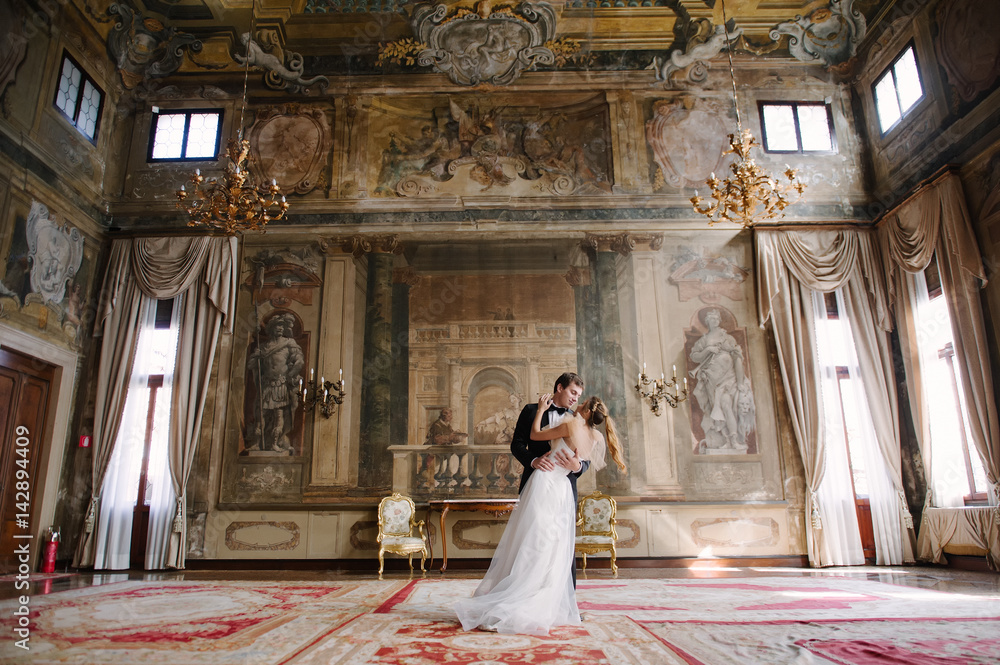 Bride and groom in a room with frescoes in Venice