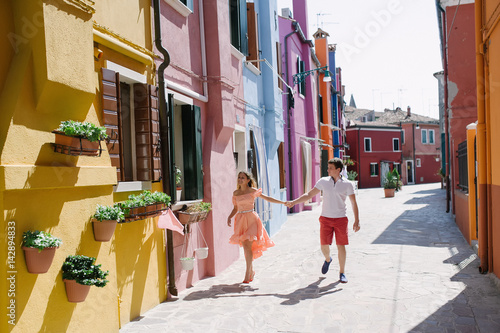 Beautiful couple walking holding hands in Burano, Venice, Italy © tanialerro