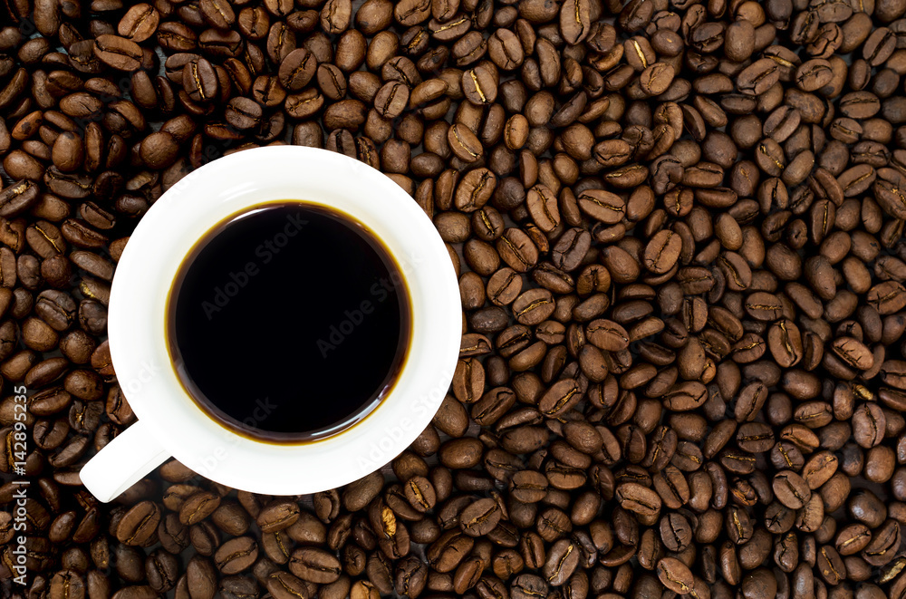 top view of cup of hot coffee and coffee bean in the background top view of cup of hot coffee and coffee bean in the background