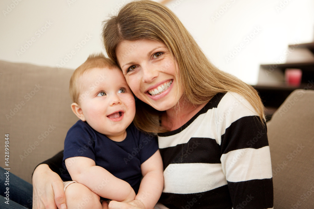 mother with her cute little son sitting on couch at home