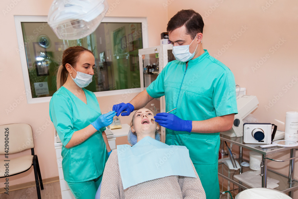 Two dentists are treating a patient Two dentists are treating a patient