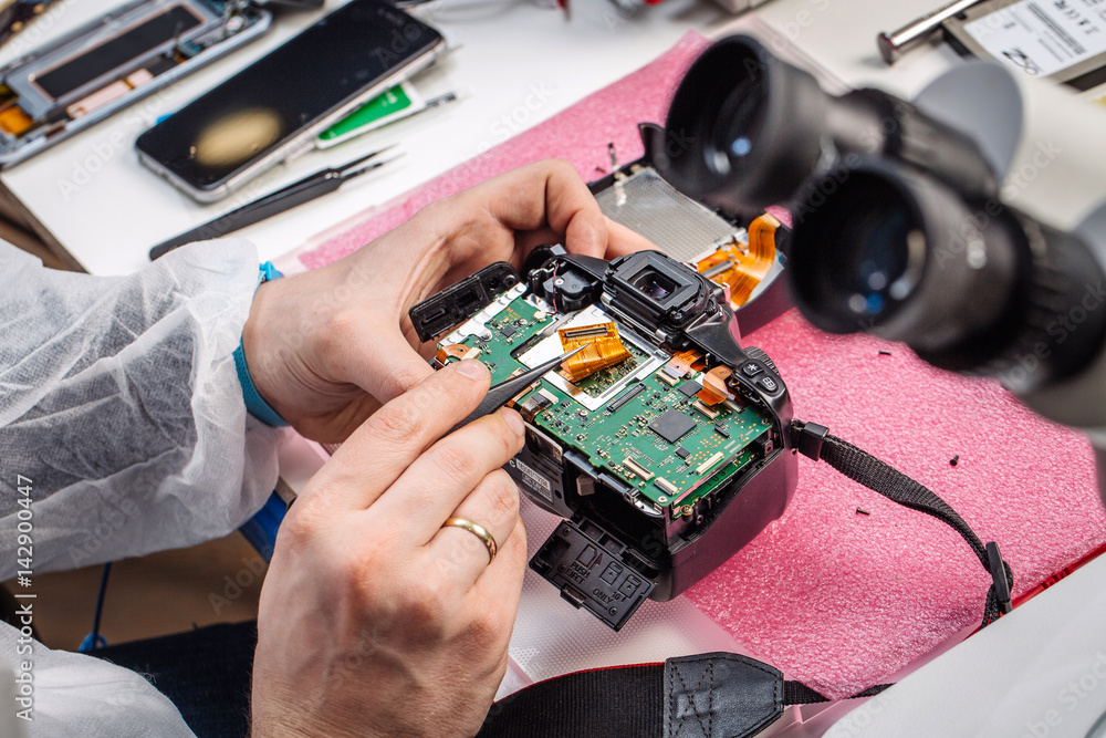 Fototapeta premium Close up hands of a service worker repairing digital camera.