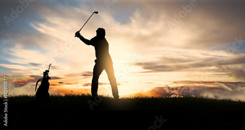 Caucasian golfer swinging golf club at sunset