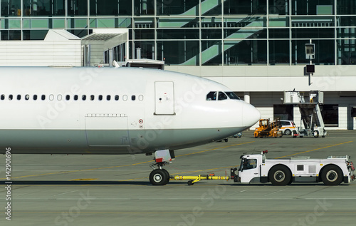 TUG Pushback tractor with Aircraft on the runway in airport.