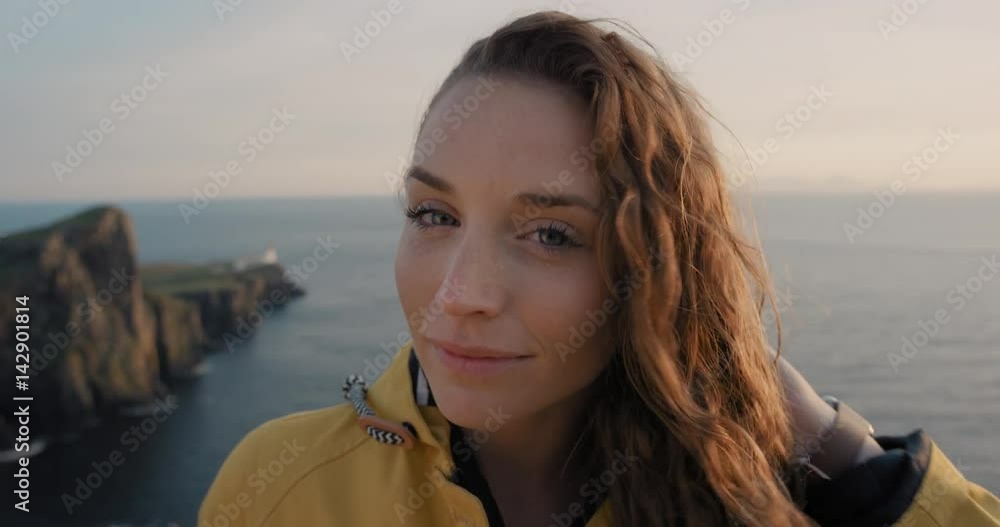 Independent Woman smiling with Red hair blowing in wind Close up portrait looking at sunset over ocean Young Girl wearing yellow raincoat trekking in Scotland Slow Motion Independent Woman smiling with Red hair blowing in wind Close up portrait looking at sunset over ocean Young Girl wearing yellow raincoat trekking in Scotland Slow Motion