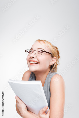 Young smiling blonde feels extremely happy and glad about great success. High achievements, good luck, joy. Grey background with copy space.