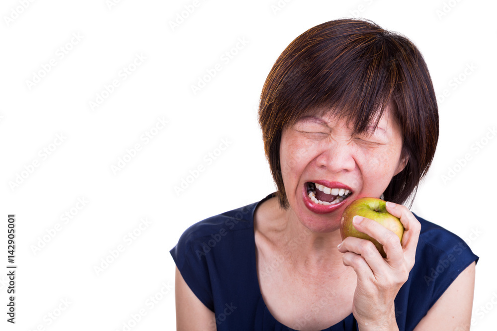 Asian women with intense toothache pain after biting apple Asian women with intense toothache pain after biting apple