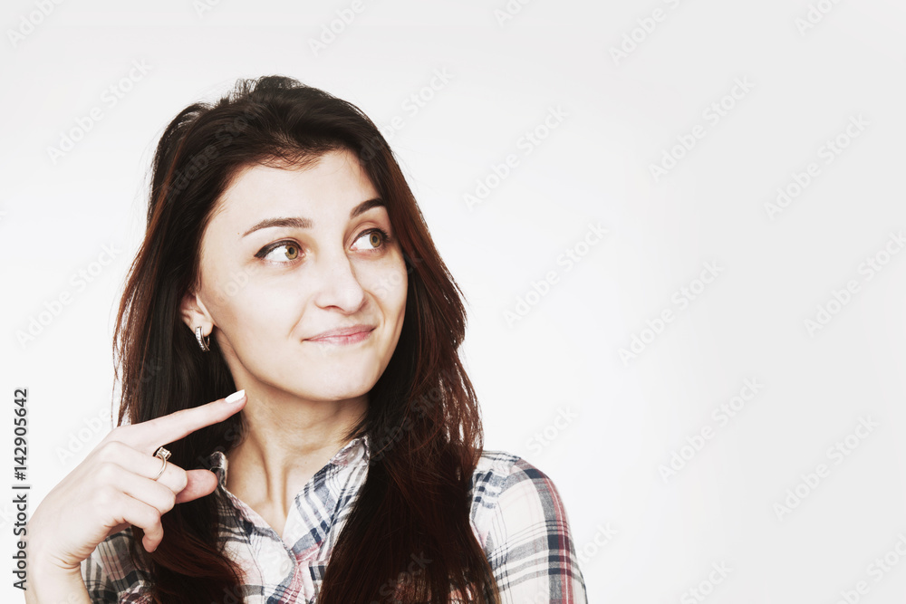 Smiling attractive young woman pointing towards copy space area Smiling attractive young woman pointing towards copy space area