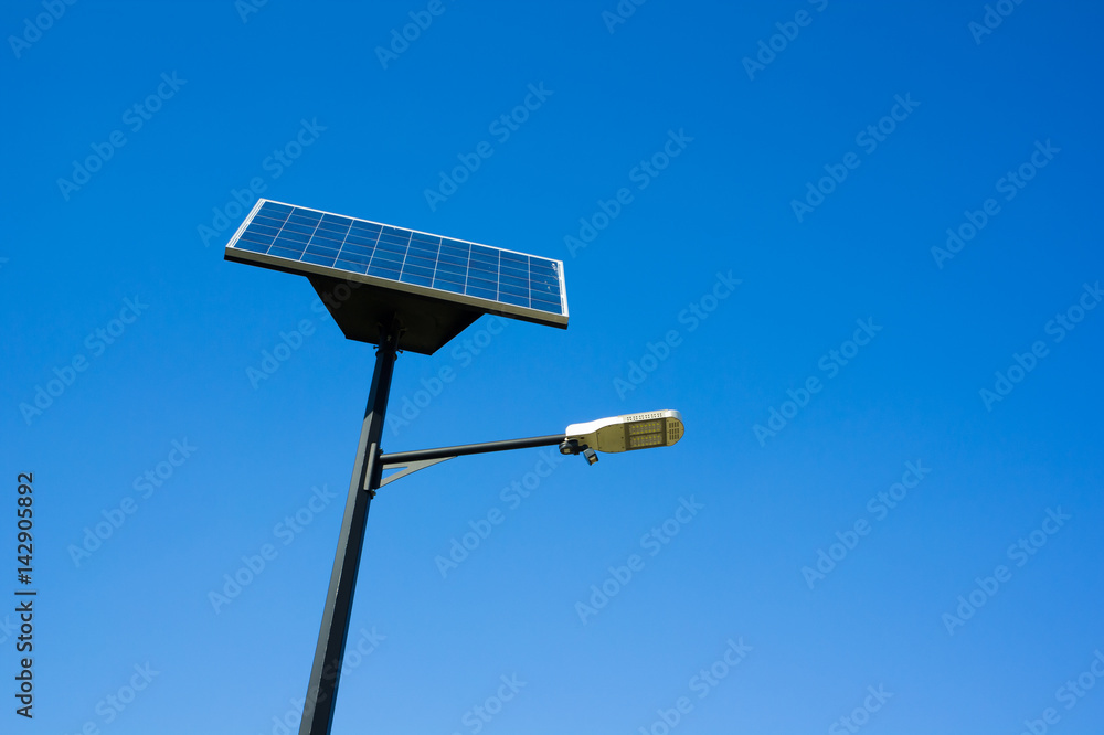 Modern lamp and solar photovoltaic panel - street lighting using renewable energy of sun to produce electricity for creating light Modern lamp and solar photovoltaic panel - street lighting using renewable energy of sun to produce electricity for creating light