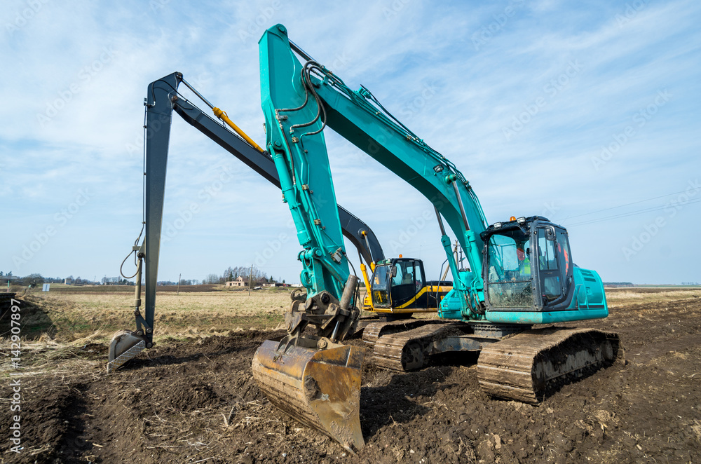 Obraz premium Two excavators stay after the hard work.