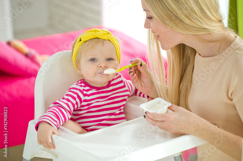A woman is feeding a young child 
