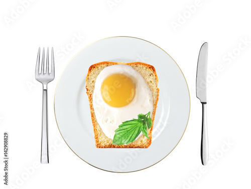 Scrambled eggs with bread and basil on plate isolated on white