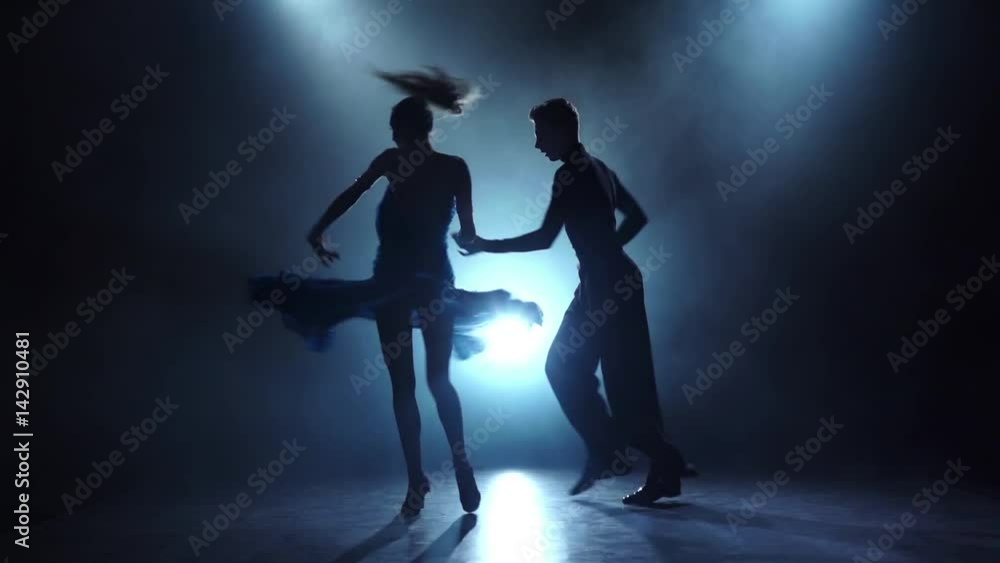 Professional couple of latinamerican dancers posing in smoky, slow motion Professional couple of latinamerican dancers posing in smoky, slow motion