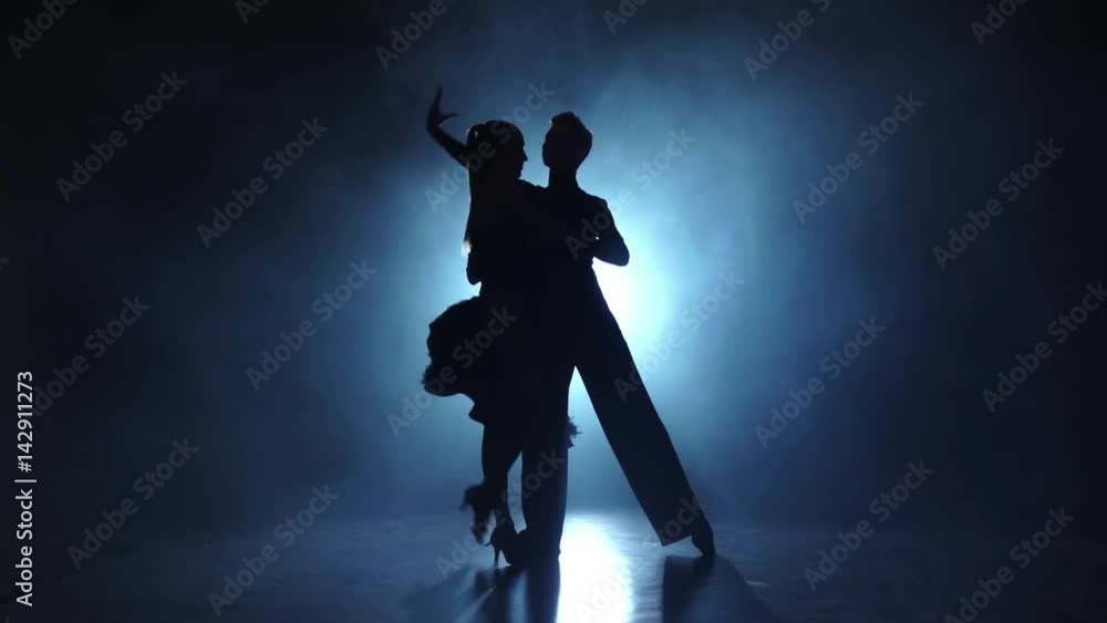 Silhouette of pair dancers performing rumba dance in slow motion Silhouette of pair dancers performing rumba dance in slow motion