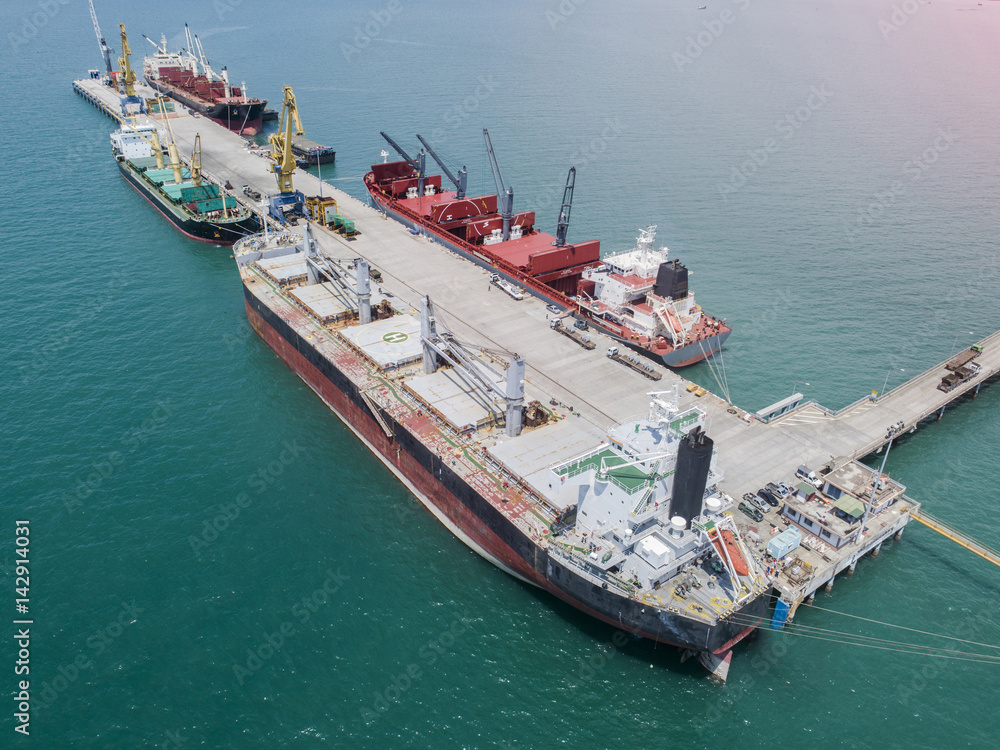 commercial vessel general cargo ship alongside of berth in port congestion for loading and discharging services in maritime transports in World wide logistics in aerial view
