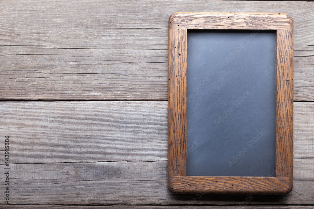 Fototapeta premium old school blackboard on a background of blackened wood panels