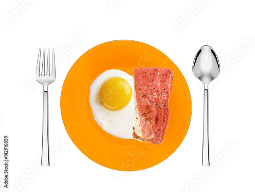 Scrambled eggs and roasted bacon with spices on orange plate with spoon and fork