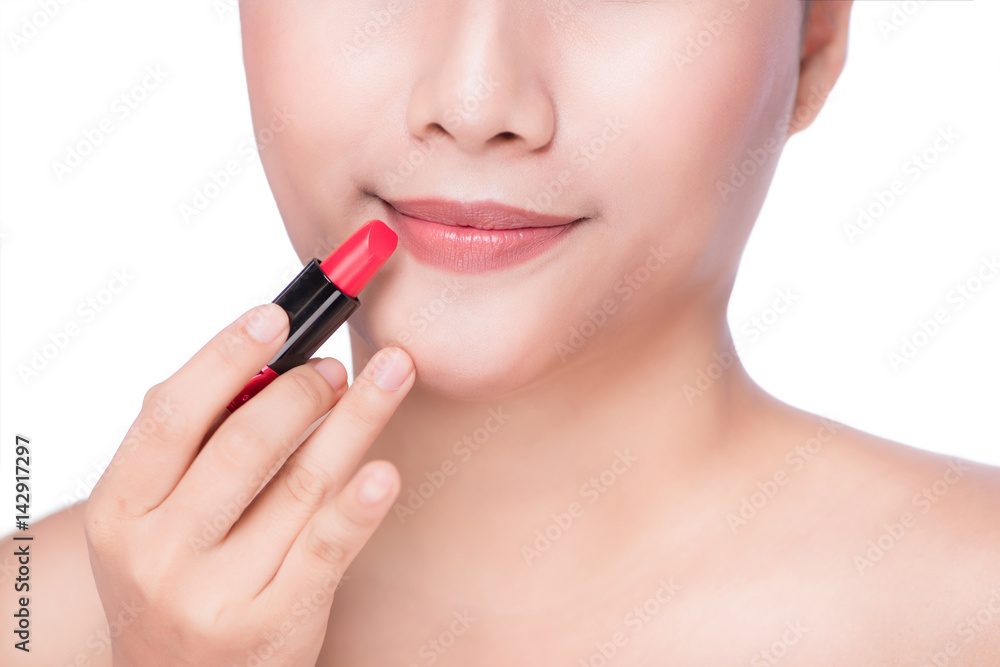Close-up of asian woman applying red lipstick on lips.