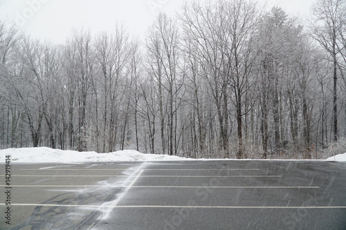 Foto empty parking lot with snow removed in front of woods