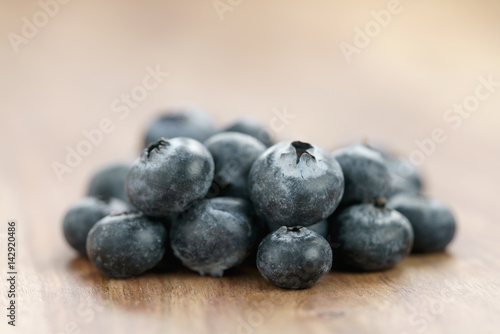 heap of fresh garden blueberries on wood table, closeup photo