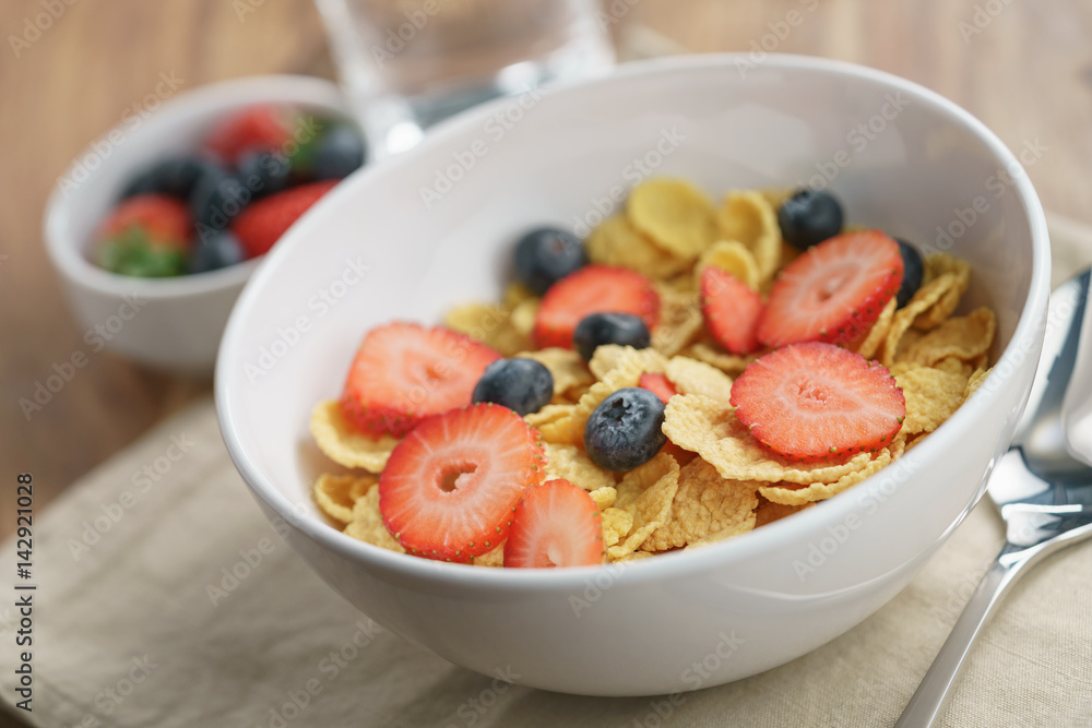 dry corn flakes with berries in bowl on table, breakfast preparation dry corn flakes with berries in bowl on table, breakfast preparation