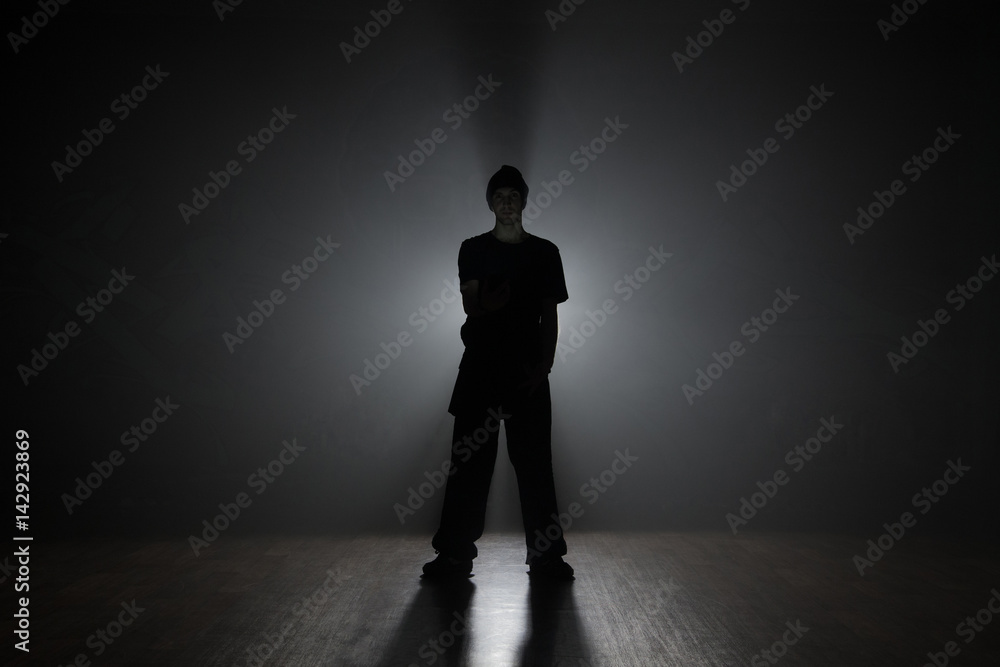 Man dancer posing in the dark and smoke Man dancer posing in the dark and smoke