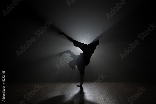 Hip-hop dancer posing backlit.