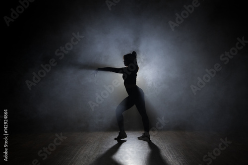 Dancer posing in the dark and smoke