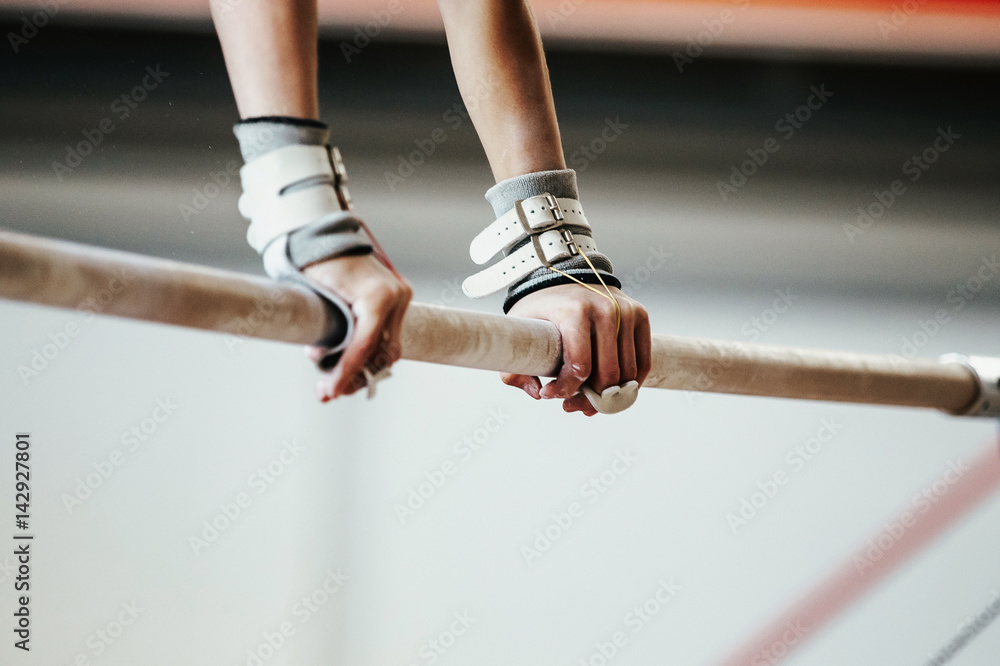 hands grips athletes female gymnast exercises on uneven bars Stock
