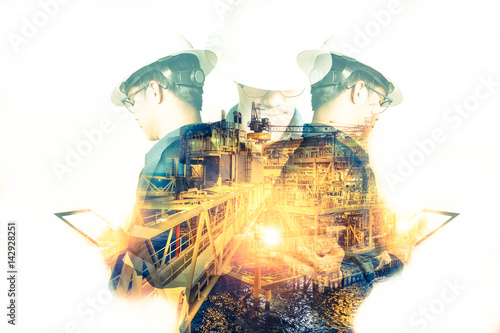 Double exposure of Engineer or Technician man with safety helmet operated platform or plant by using tablet with offshore oil and gas platform background for oil and gas business concept