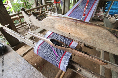 old weaving Loom and thread of yarn. A traditional hand-weaving loom being used to make cloth at home.