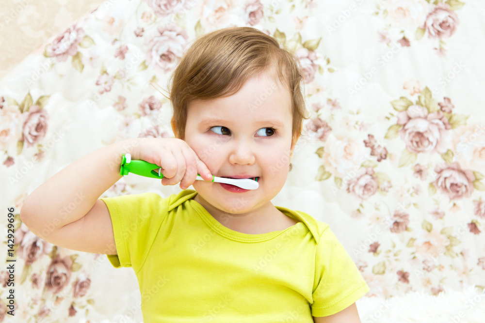 A little girl is cleaning her own teeth. The concept of care, beauty and health A little girl is cleaning her own teeth. The concept of care, beauty and health